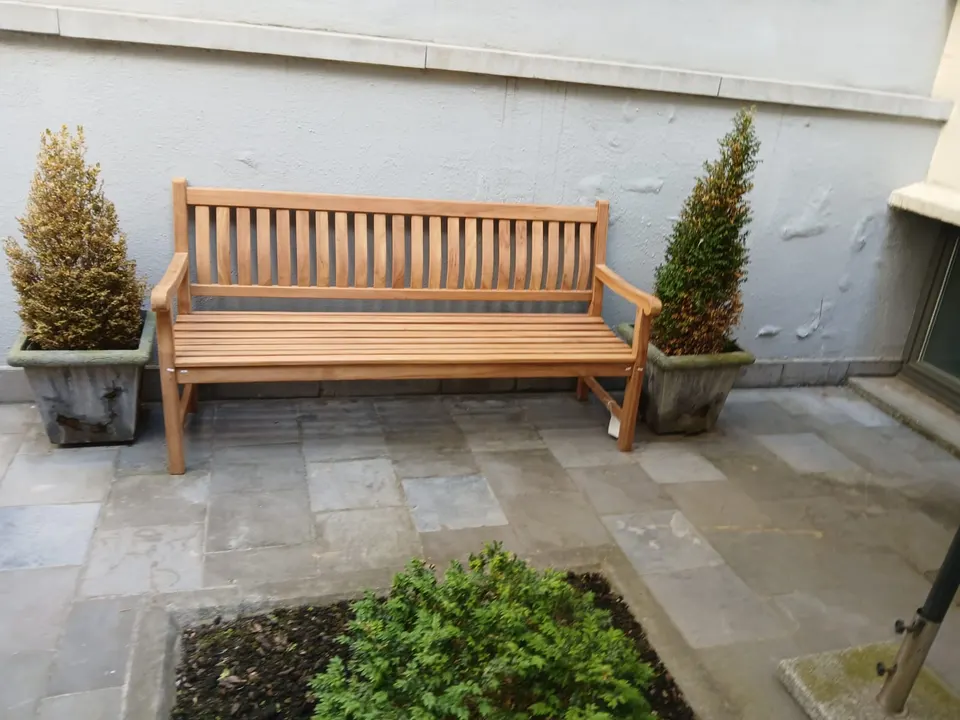 Banc en teck de 180 cm dans une cour pavée